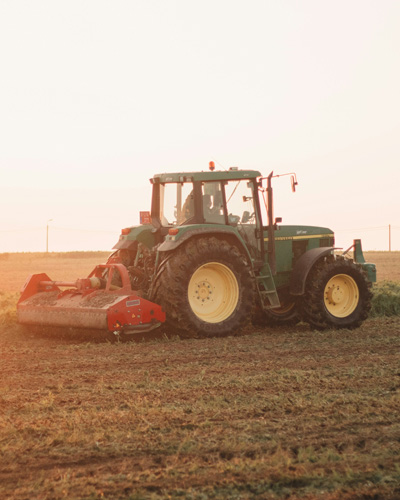 Traktor auf einem Feld bei Sonnenuntergang